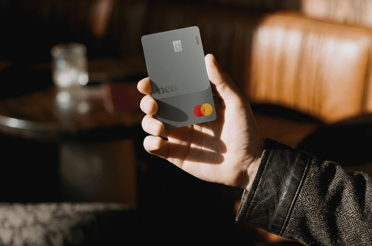 A person's hand holding the Neo World Mastercard, a contender for one of the best cash back credit cards in Canada