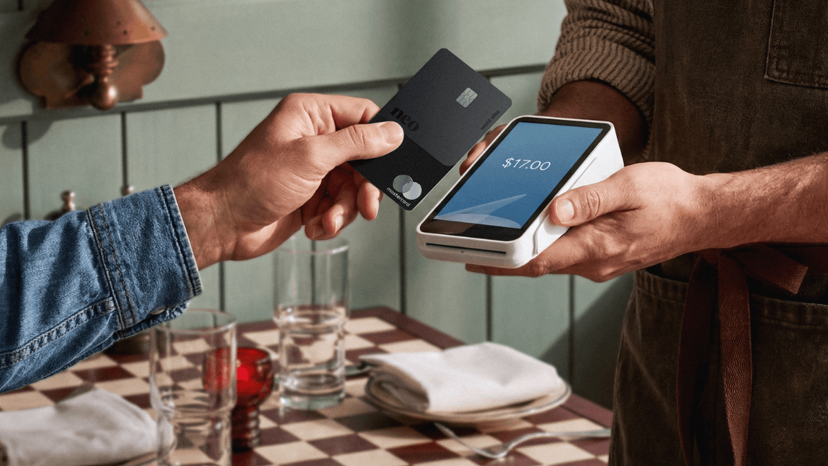 A person tapping to pay at a restaurant using the secured version of the Neo Mastercard, one of the best secured credit cards in Canada